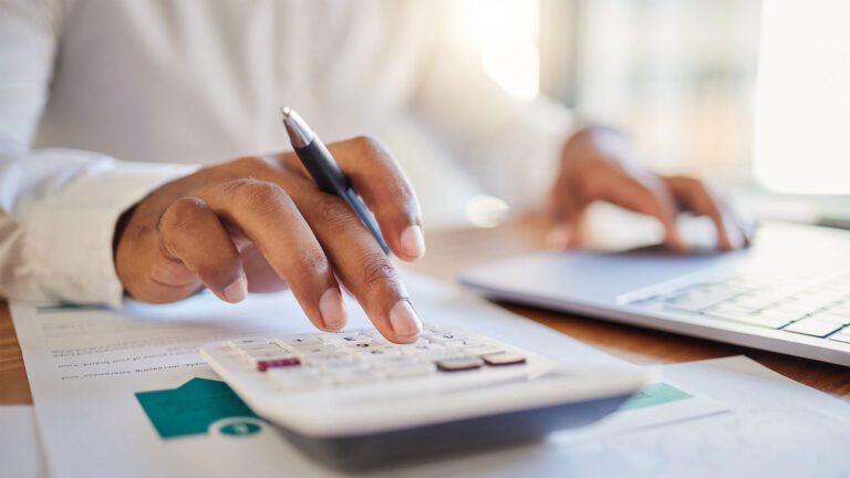 Person using calculator and completing paperwork