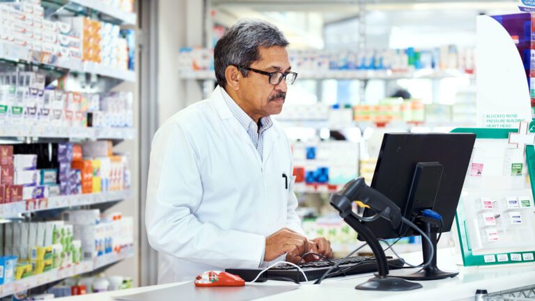 Pharmacy team member working on computer in the pharmacy.