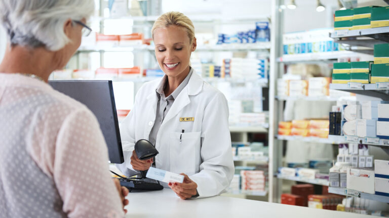 Pharmacy professional helping patient at the pharmacy counter.