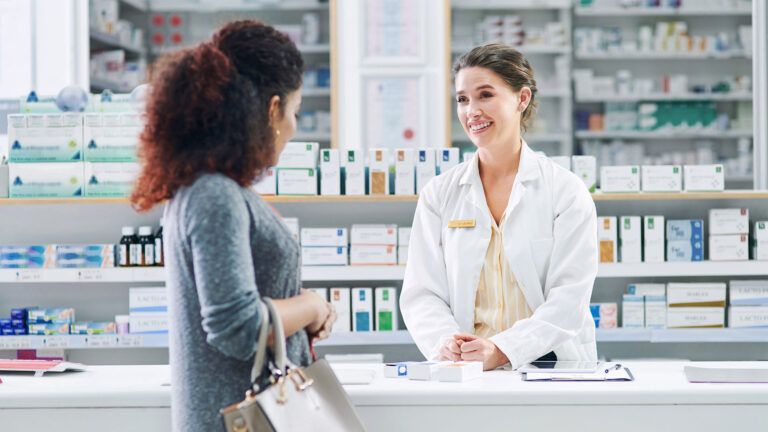 Pharmacy professional talking to patient in the pharmacy